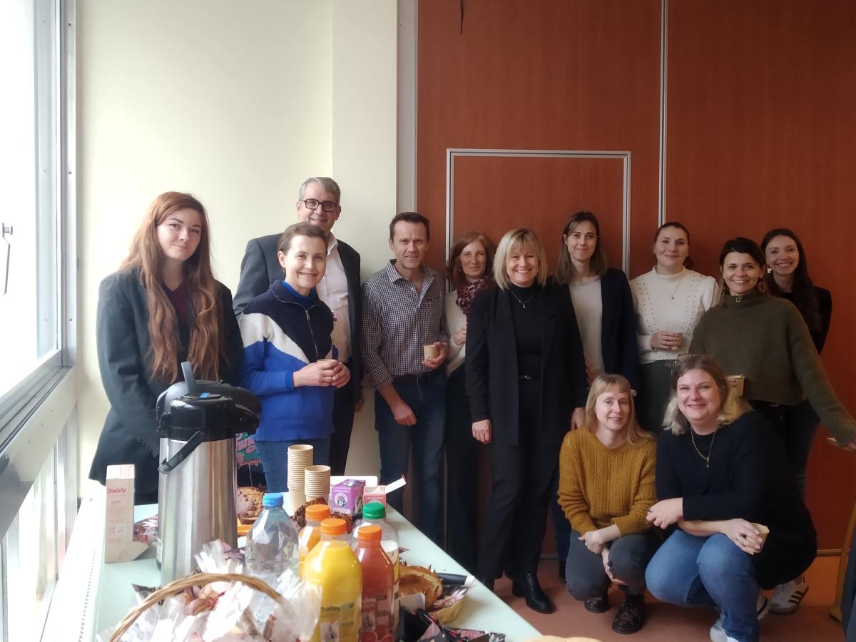 Une douzaine de personnes sourient devant un buffet.